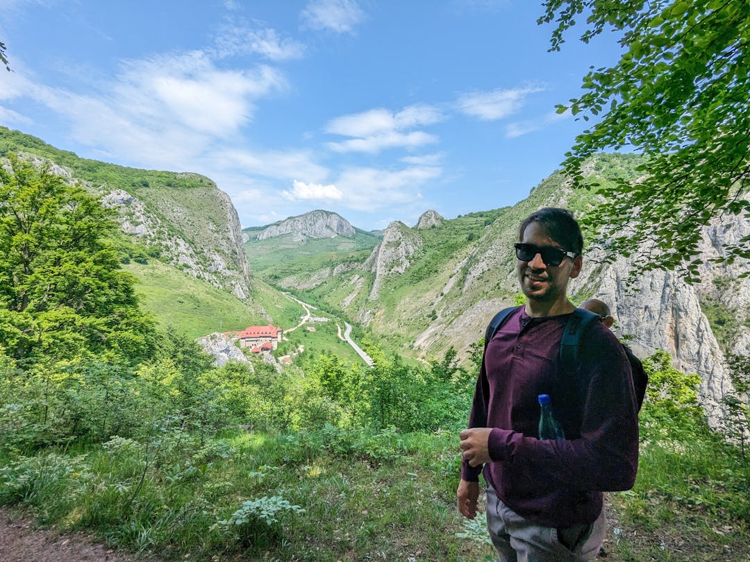 A man with a backpack standing in the mountains