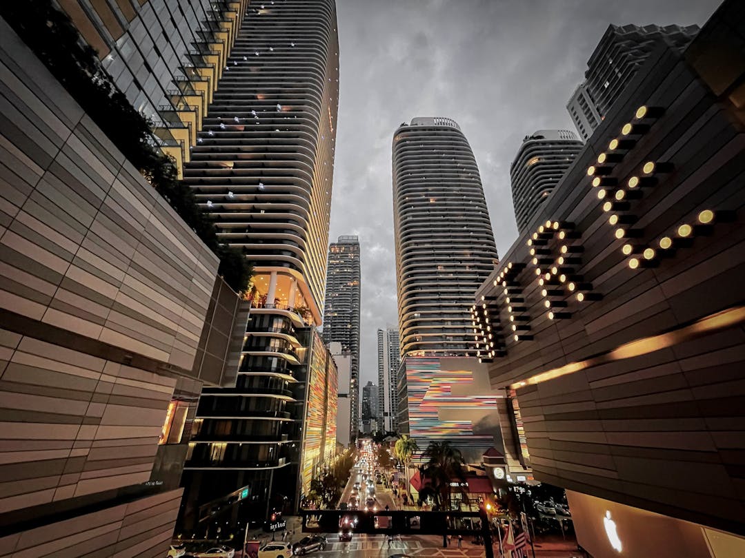 A city street filled with tall buildings under a cloudy sky