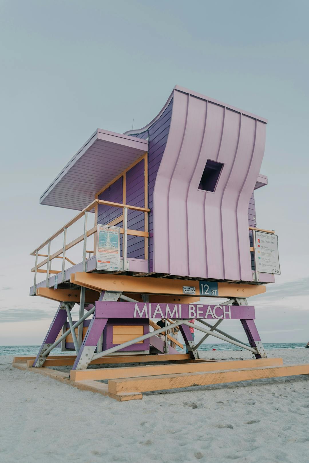 A pink and purple lifeguard tower on a beach