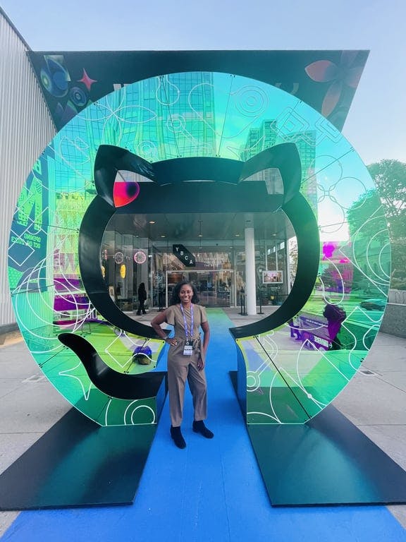 A woman standing in front of a giant GitHub sculpture