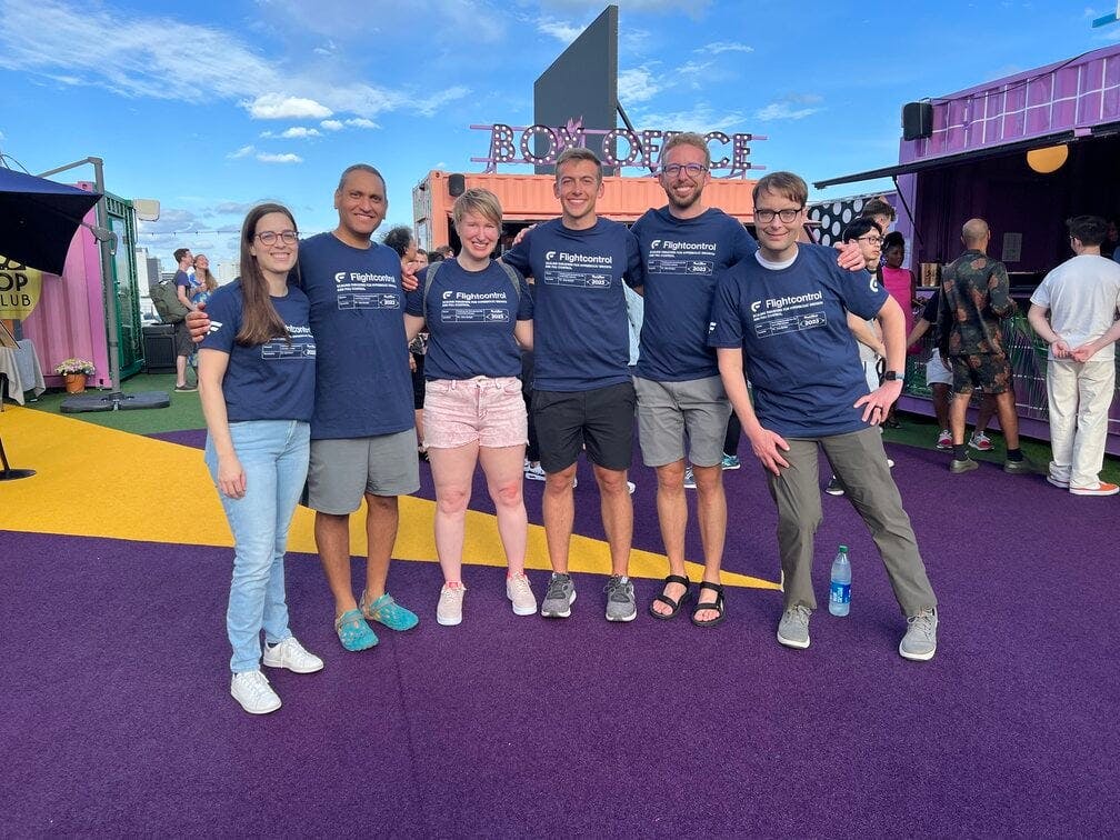 A group of people standing on a purple carpet