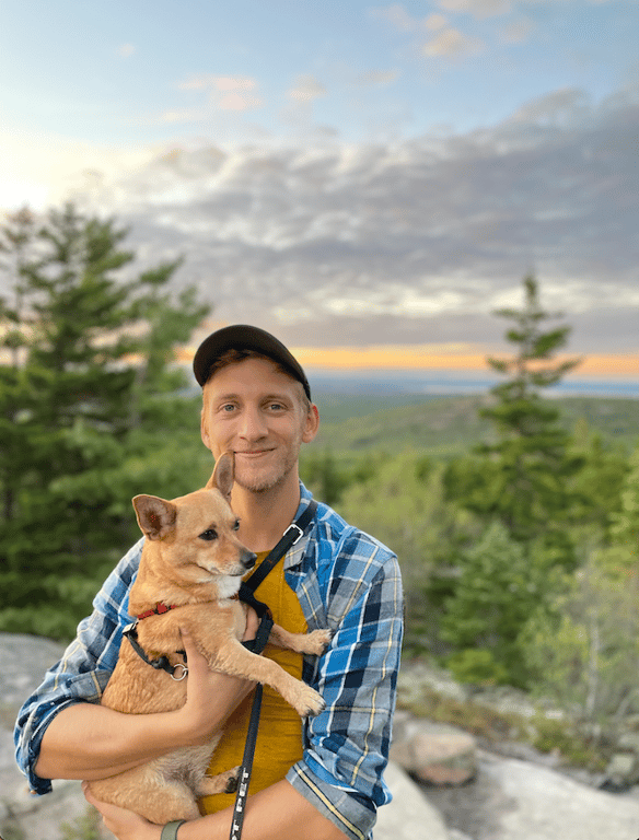 A man holding a small dog in his arms