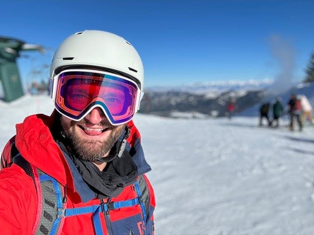 A man wearing a helmet and goggles on a ski slope