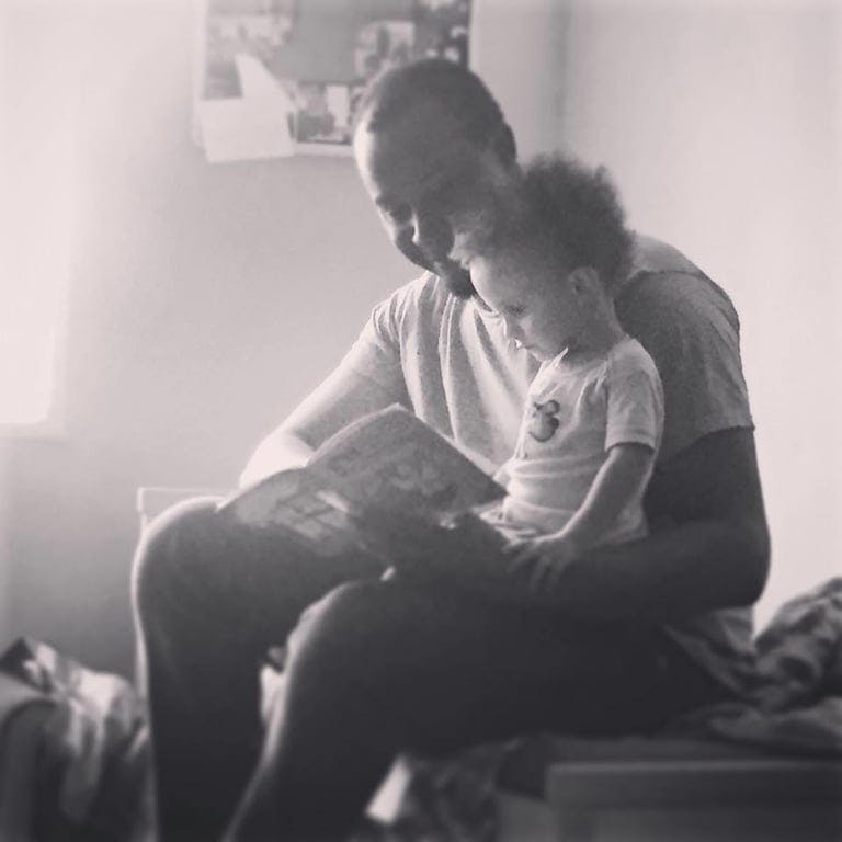 A man reading a book to a child