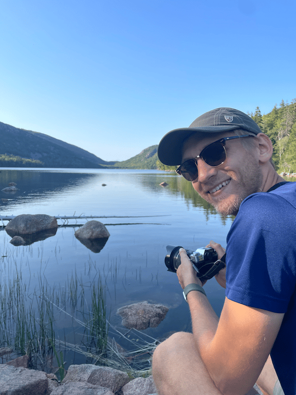 A man taking a picture of himself in front of a lake