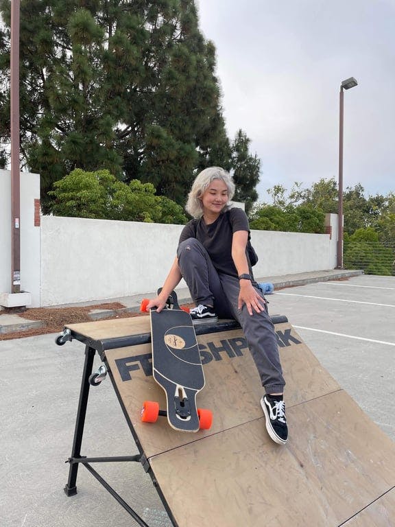 A woman sitting on top of a skateboard ramp