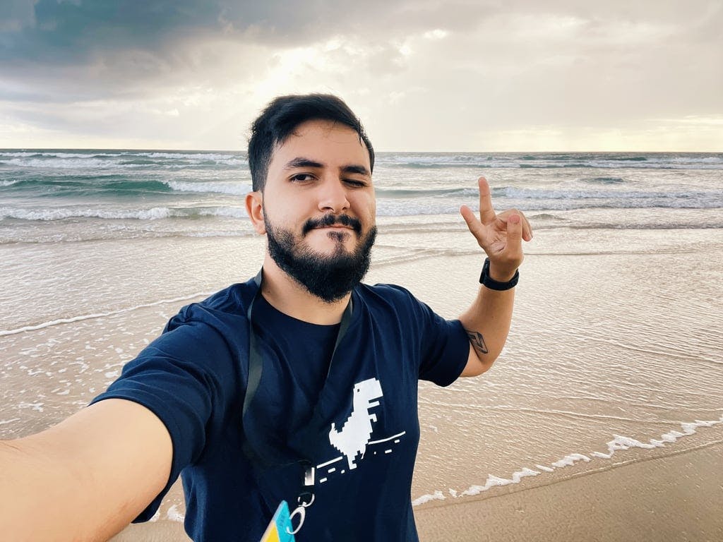 A man on the beach making a peace sign